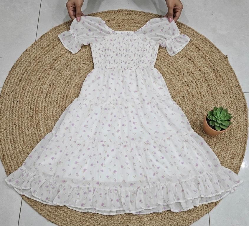 Embrace effortless romance with this ethereal maxi dress. Crafted from a lightweight, breezy fabric, this dress features a delicate ditsy floral print in soft lavender tones against a creamy off-white backdrop